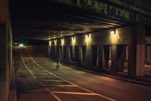 Cycliste sur vélo de route Opus sous un viaduc la nuit