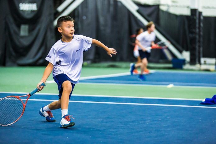 Jeune Garcon Concentré Sur Sa Technique Durant Un Cours De Tennis Canada Kids
